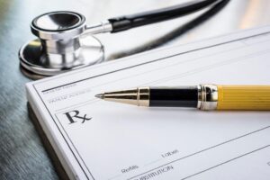 a doctors prescription pad pen and stethoscope