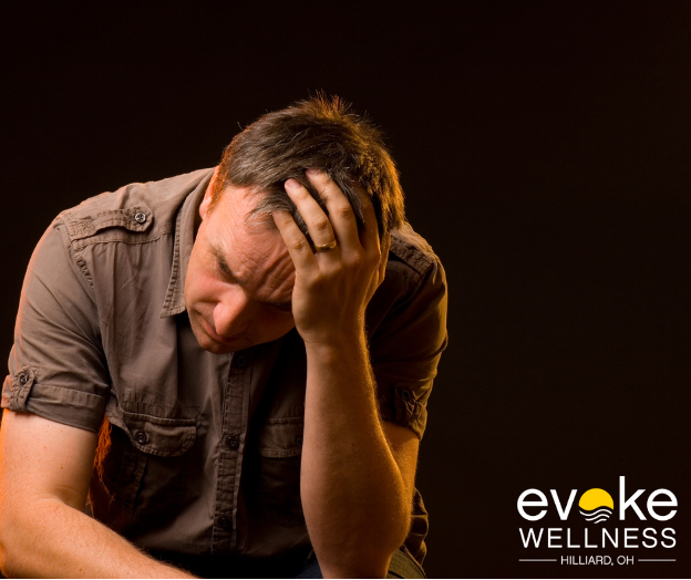 a man sits with his head in his hand